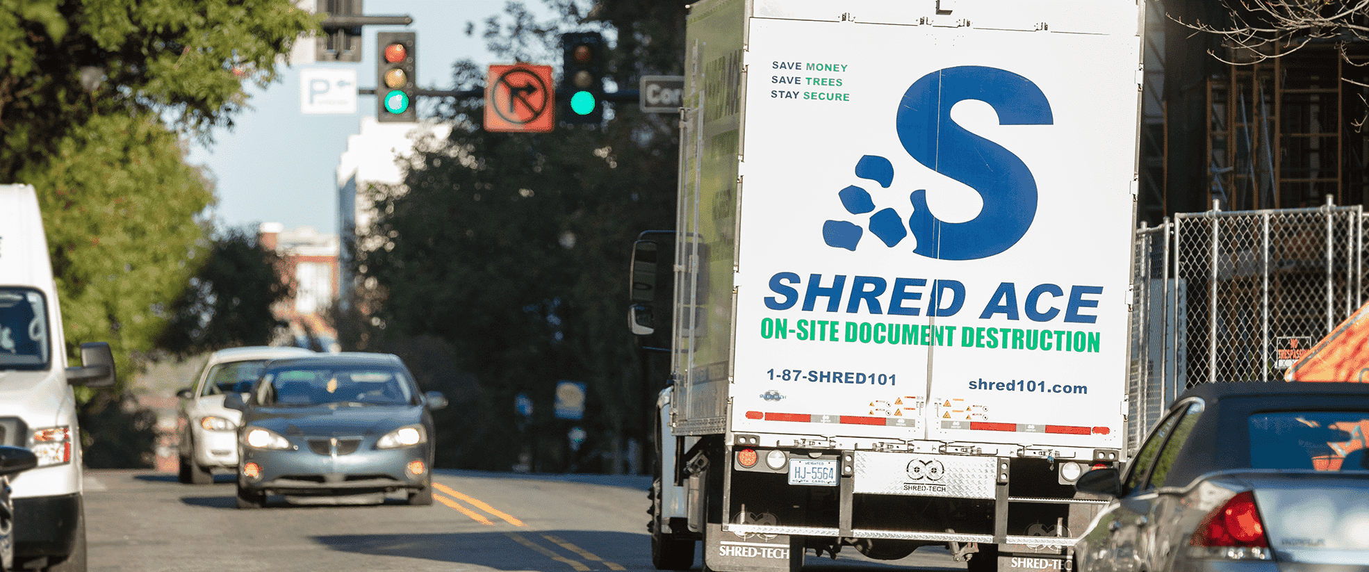 shred-ace-truck-in-street-with-cars-min